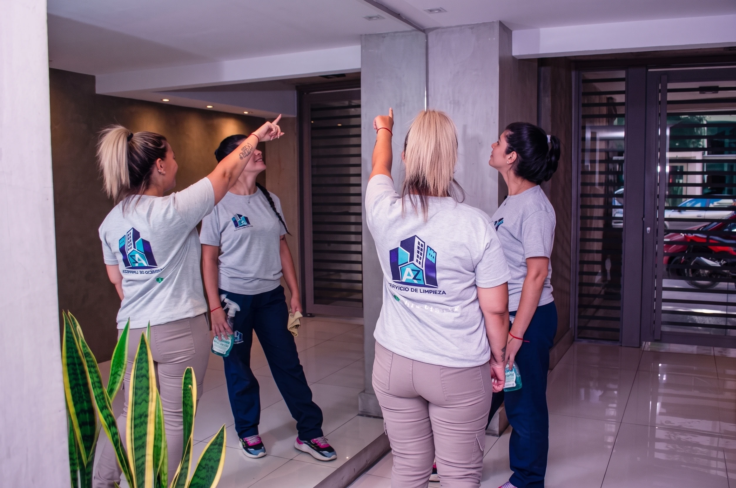 Personal de AZ Servicios de Limpieza trabajando con uniforme en el hall de un edificio